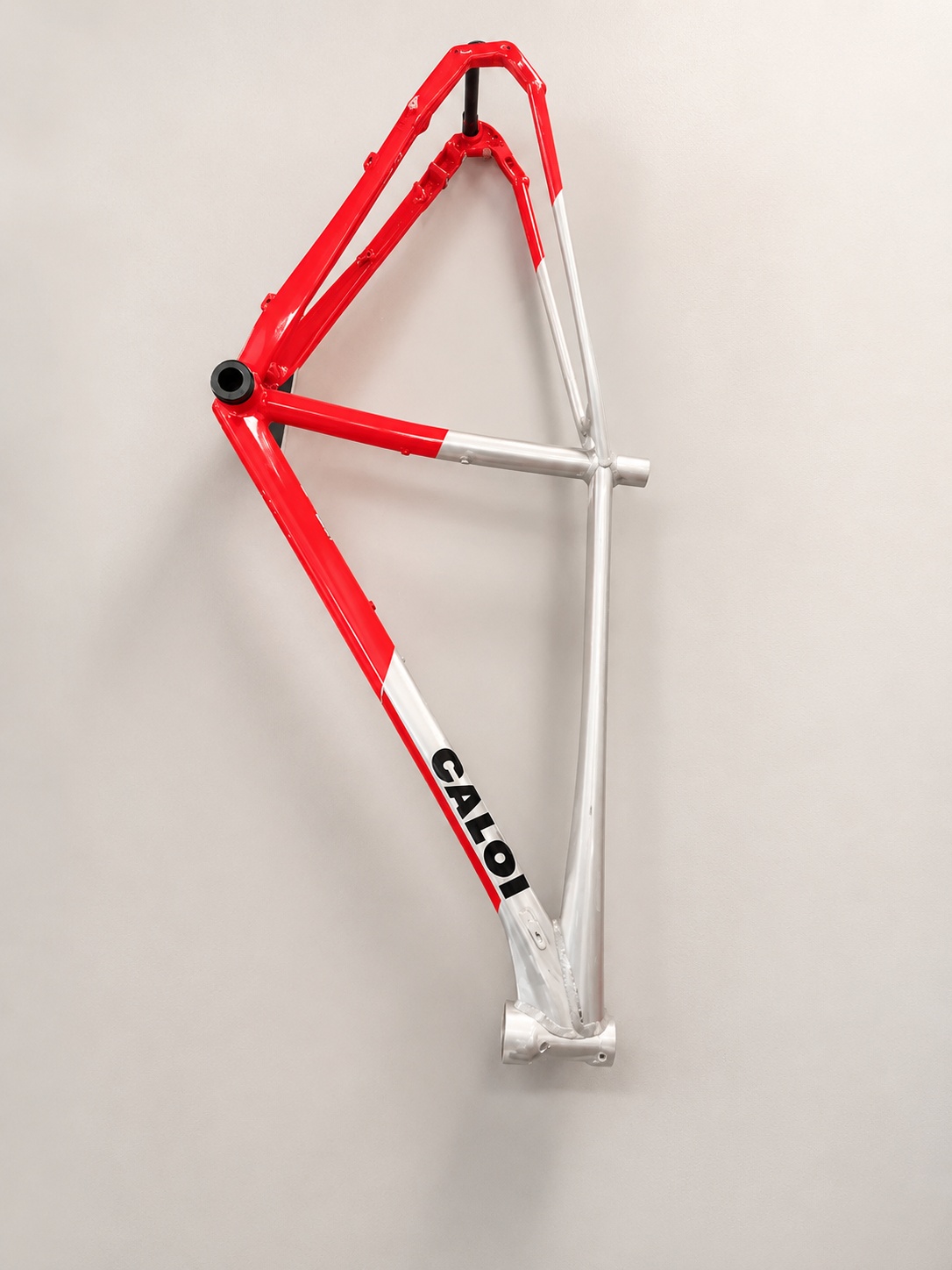 Quadro Caloi Elite vermelho e prata em uma parede limpa